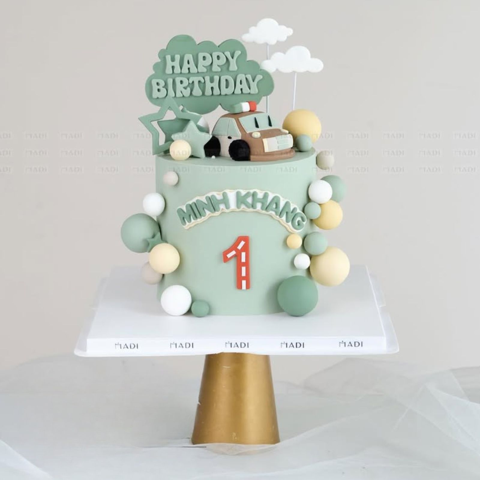 Bánh kem đầy tháng chủ đề xe địa hình với sắc xanh olive phối cùng tông be hiện đại, mang tinh thần phiêu lưu đầy mạnh mẽ cho bé