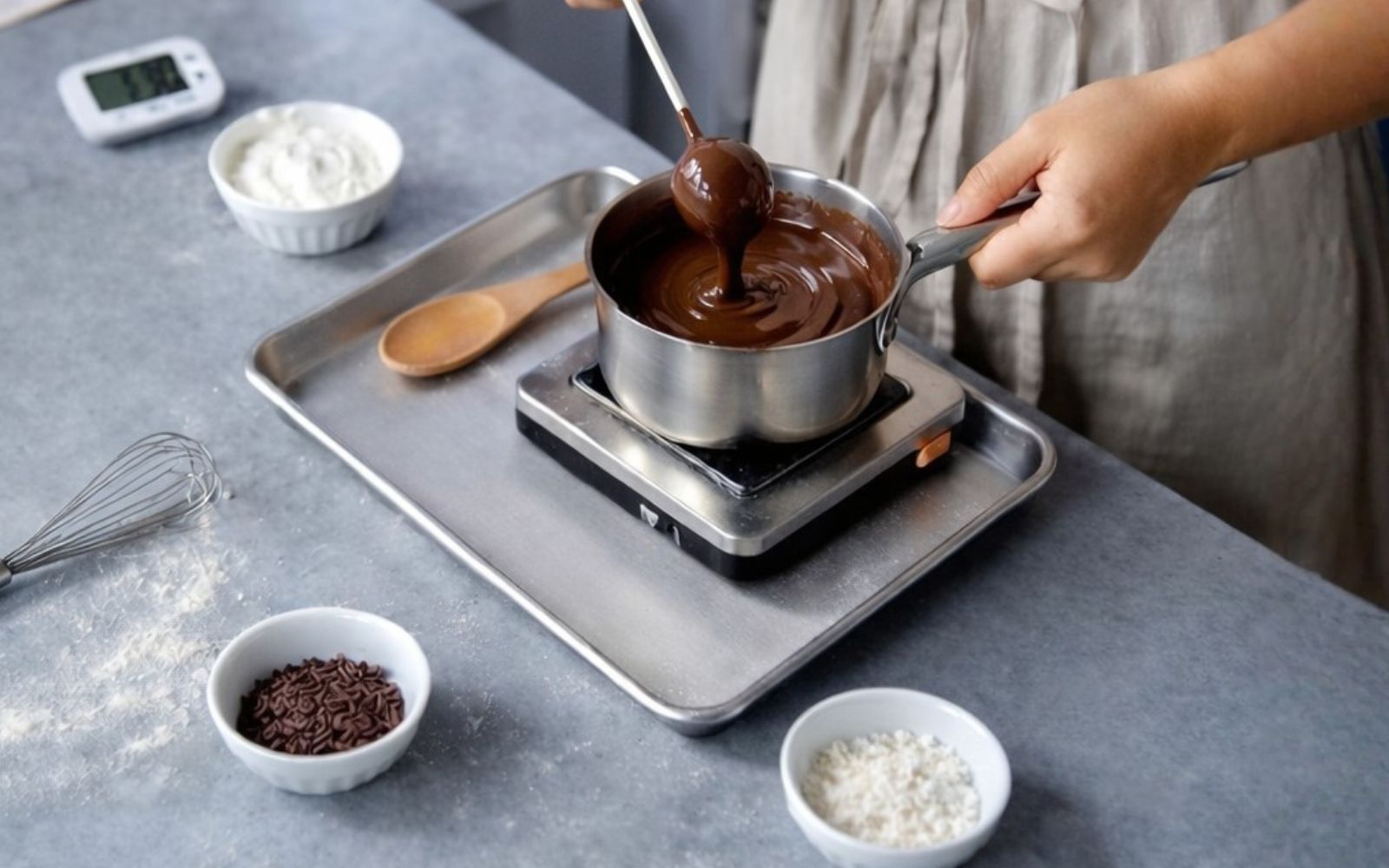 Cắm que vào viên bánh Cake Pop, sau đó nhúng đều qua lớp chocolate phủ