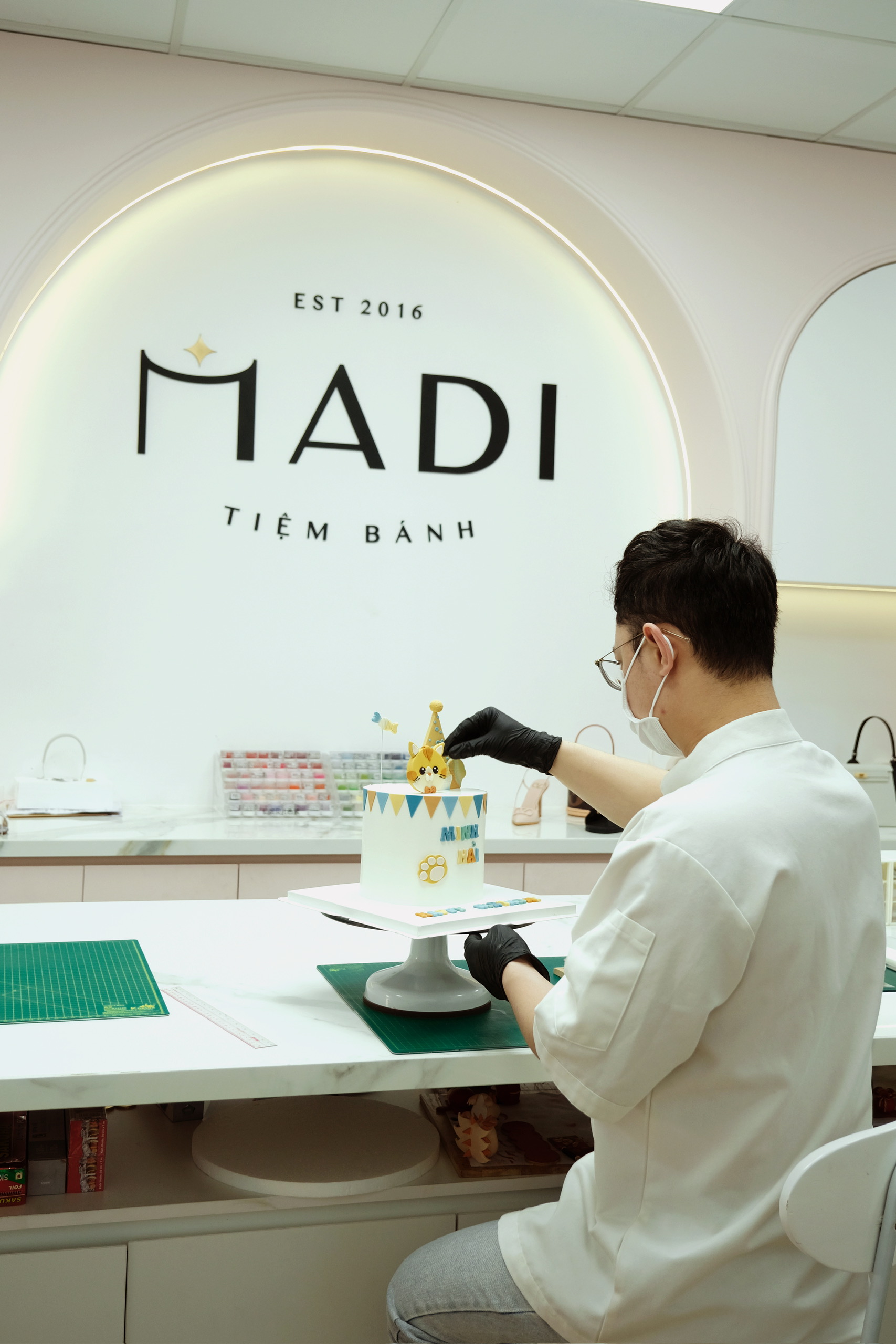 Nghệ nhân MaDi hoàn thiện chi tiết trang trí trên bánh kem tại bếp