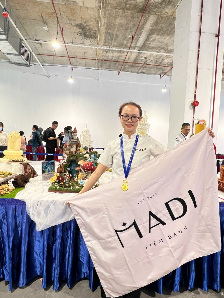 Nghệ nhân MaDi đeo huy chương vàng hạng mục Sugar Art tại cuộc thi bánh quốc tế